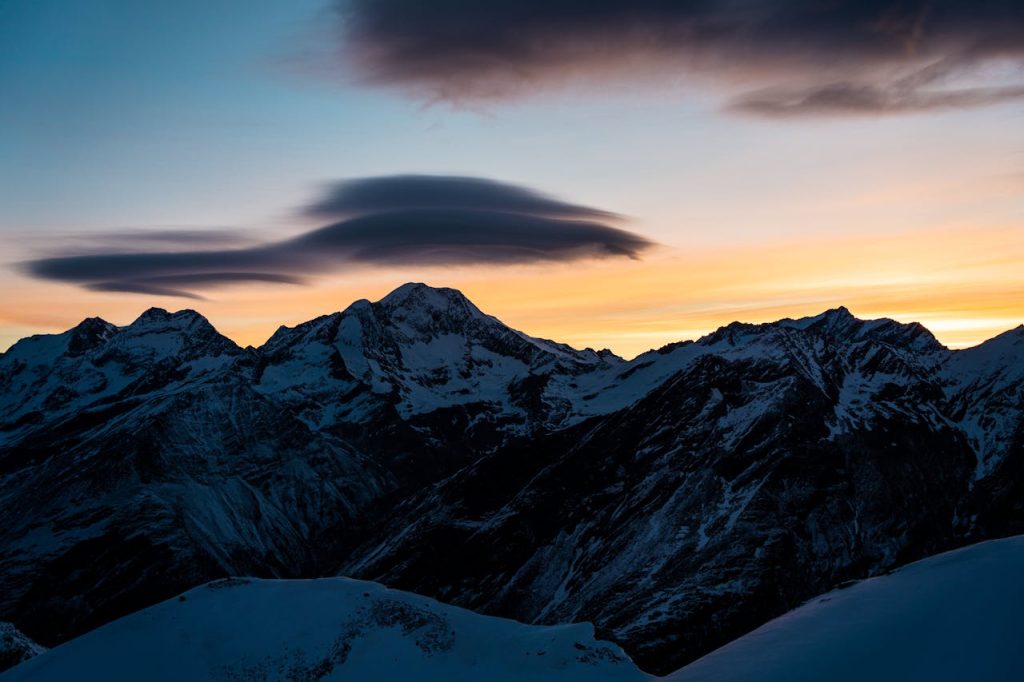 Stunning winter sunset over the snow-capped mountains in Saas Fee, Switzerland.